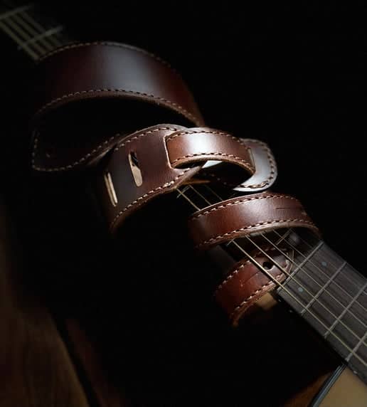 Handcrafted Leather Guitar Strap wrapped around guitar 